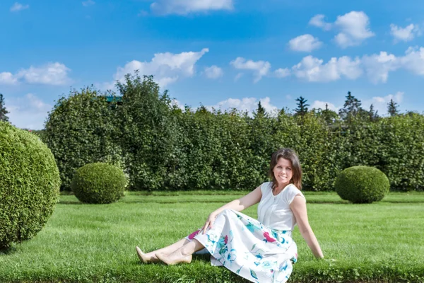 Moda di bella bella giovane donna hipster è seduto su erba verde in una camicetta e gonna lunga — Foto Stock