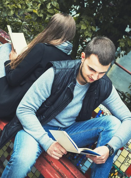 fashion of nice pretty young hipster woman is sitting back to  with a  handsome man and reading  book