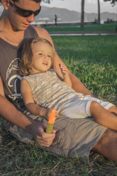 daughter sitting on the lap of dads