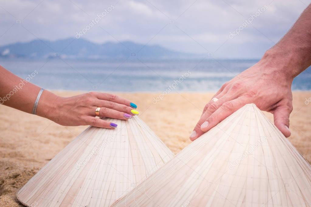 Hands of man and woman with ring, Vietnamese national hats, asia, hands on hats