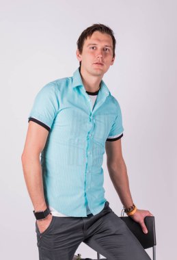 Yakışıklı çekici. genç adam resmi kıyafeti ceplerinde, el ele tutuşarak ayakta, gri arka planı süre kamera bakıyor