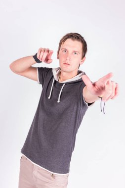 Resmi kıyafeti sevimli yakışıklı genç adam onun ellerini, ince ve sert parmaklar ayakta beyaz arka planı süre kamera ile puan tutar