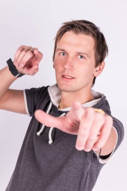 Resmi kıyafeti sevimli yakışıklı genç adam onun ellerini, ince ve sert parmaklar ayakta beyaz arka planı süre kamera ile puan tutar