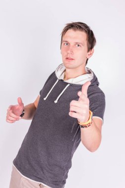 Resmi kıyafeti sevimli yakışıklı genç adam onun ellerini, ince ve sert parmaklar ayakta beyaz arka planı süre kamera ile puan tutar