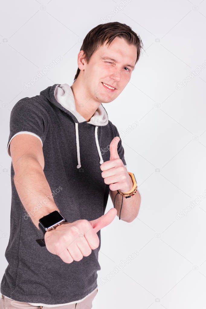 Charming handsome young man in formalwear points with fingers,Raised up, lux at camera while standing white background
