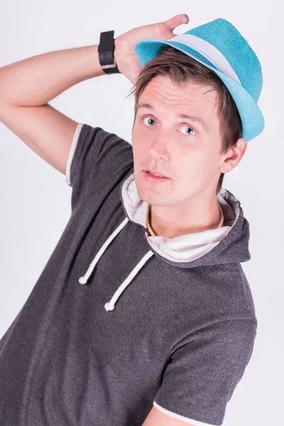Encantador joven guapo en formalwear Sostiene un sombrero azul fondo blanco — Foto de Stock