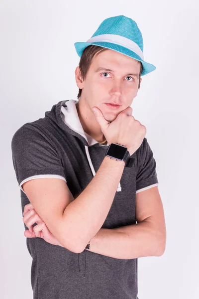 Encantador joven guapo en formalwear Sostiene un sombrero azul fondo blanco — Foto de Stock