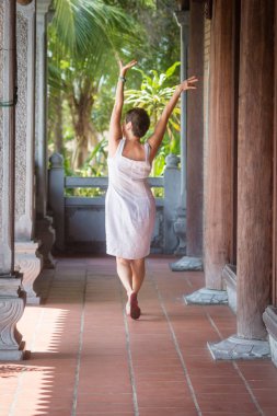 Ahşap sütunlarla koridorun yürüyen esmer orta yaşlı kadın