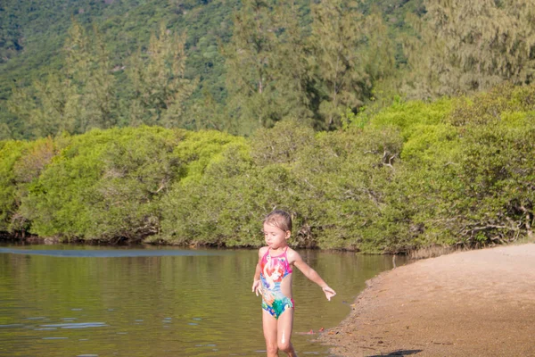 Joven linda niña jugando en el agua en un hermoso río en un día soleado de verano —  Fotos de Stock