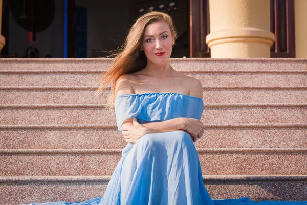 Jolie fille mariée jeune femme mignonne sexy Dans une longue robe bleue se trouve sur les marches des escaliers. Le train est sur eux — Photo
