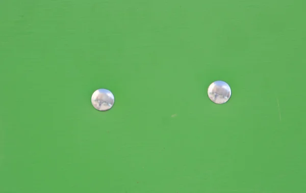 緑の板のテクスチャの 2 つのリベットのクローズ アップ. — ストック写真