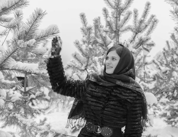 Close up of a girl in a scarf holding a Christmas tree black and white — Stock Photo, Image