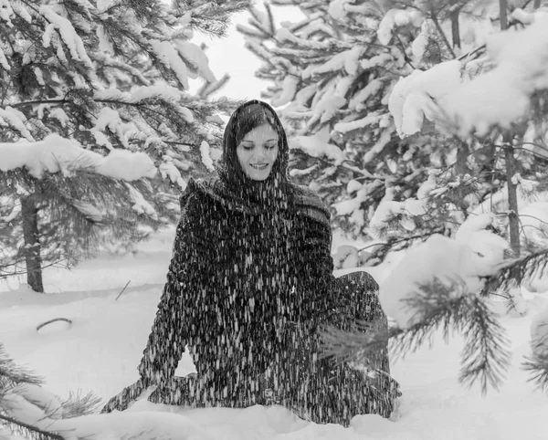 Ragazza in una sciarpa nel bosco getta la neve in bianco e nero . — Foto Stock