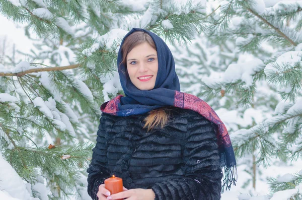 Russian beauty near snow-covered trees with a candle — Stock Photo, Image