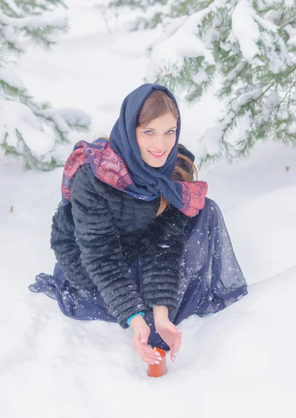 Russian beauty on the edge of a snowy forest with a candle. — Stock Photo, Image