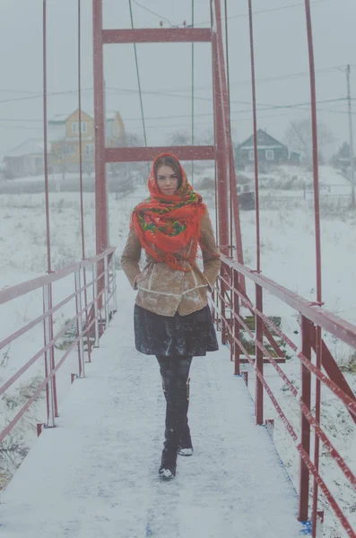On the bridge in winter beautiful girl in the Board. — Stock Photo, Image