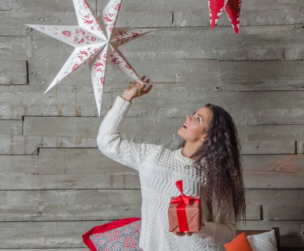 Hermosa chica mirando en la Navidad juega con la estrella . — Foto de Stock