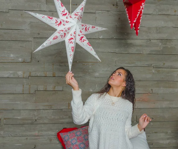 Antes de Navidad hermosa chica en un suéter blanco jugando con la estrella de Navidad . — Foto de Stock