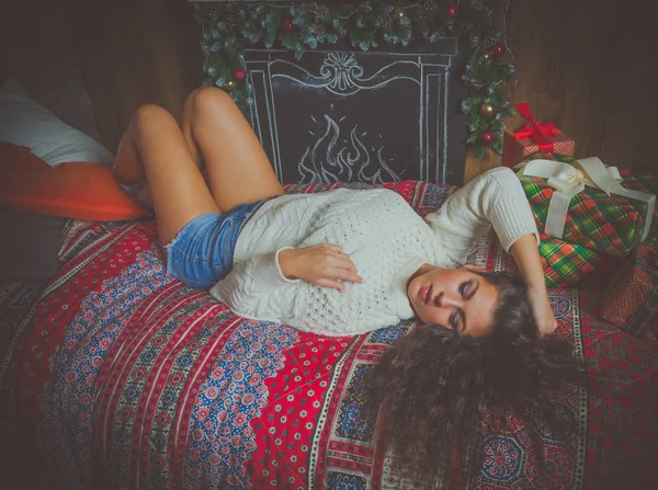 Szexi lány a fehér pulóver karácsonykor fekszik álmodik. — Stock Fotó