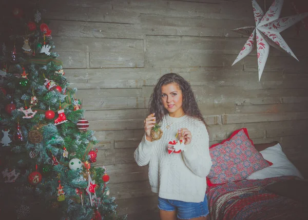 Sexy chica en suéter blanco en la víspera de Navidad con juguetes de Navidad . — Foto de Stock