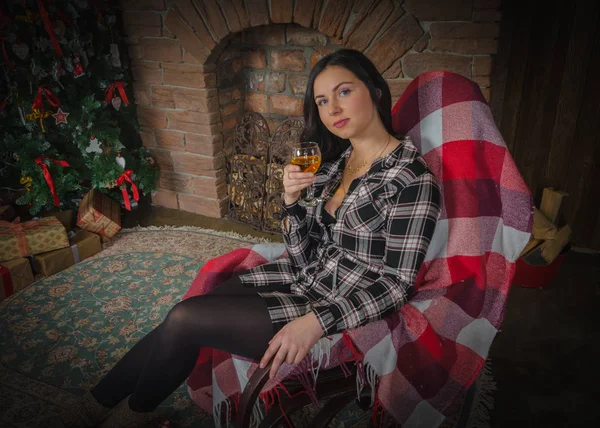 Una chica con azul sentado en una silla con una copa de vino en Navidad — Foto de Stock