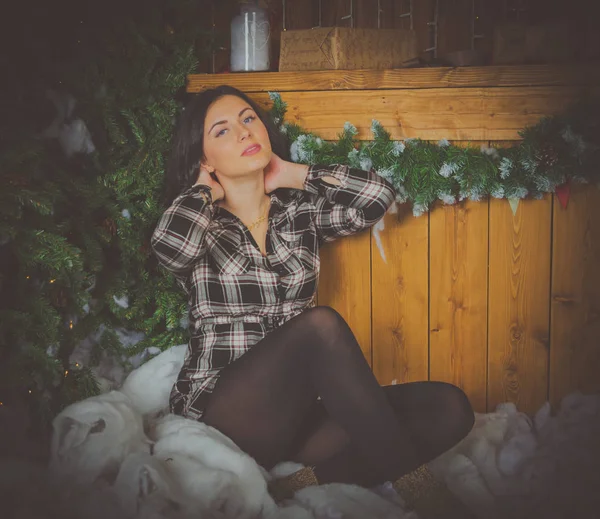 Hermosa chica en camisa a cuadros en el mostrador y el árbol de Navidad . — Foto de Stock