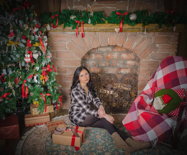 크리스마스 아름 다운 소녀는 벽난로 근처에 앉아 — 스톡 사진