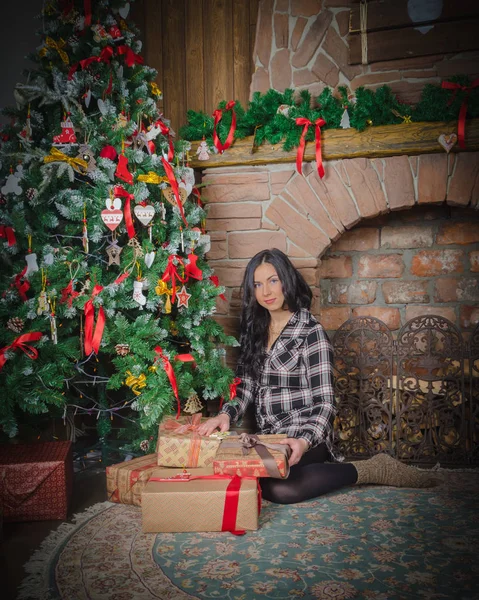 Chica en camisa sentado cerca del árbol en la víspera de Navidad . — Foto de Stock