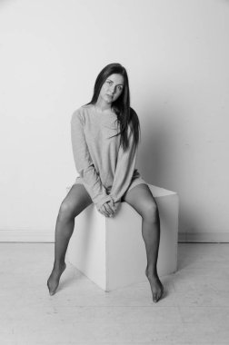 meydanda, küp bir kız büyük bir t-shirt oturur.