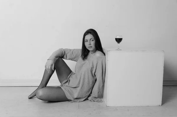 Όμορφο κορίτσι που κάθεται κοντά στο cube της πλατείας στην οποία βρίσκεται ένα ποτήρι κρασί — Φωτογραφία Αρχείου