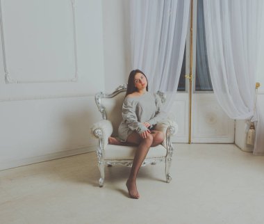 antika sandalye güzel bir kız Mike içinde oturur..