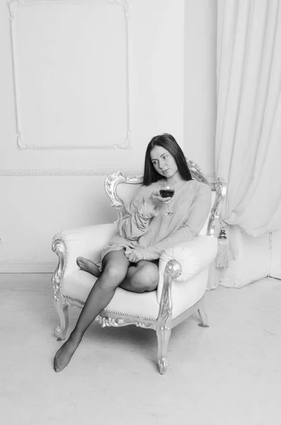 Μαύρο λευκό vintage καρέκλα με ένα ποτήρι κρασί ένα όμορφο κορίτσι σε ένα t-shirt — Φωτογραφία Αρχείου
