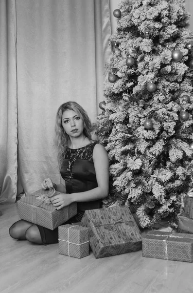 Schwarz weiß, Heiligabend würziges Mädchen im Abendkleid auf dem Fußboden bei den Geschenken. — Stockfoto