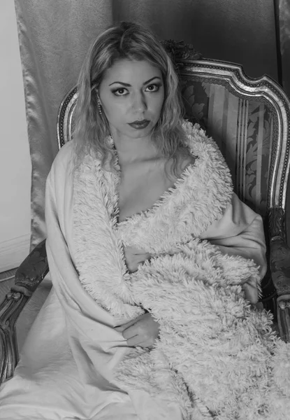Avvolto in una coperta seduta carina sono una ragazza, in bianco e nero . — Foto Stock
