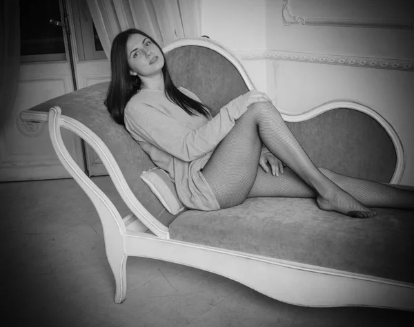Schwarz-weiß, schönes Mädchen in Spaghetti posiert auf der Couch — Stockfoto