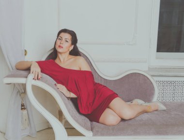  kameraya, kanepede poz Kırmızı elbiseli çekici kız görünüyor