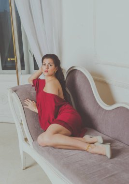 kanepede poz Kırmızı elbiseli güzel kız