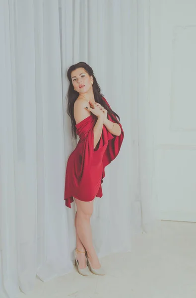 Janela posando menina bonita em um vestido de Borgonha — Fotografia de Stock
