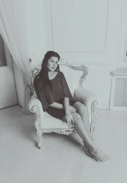 Ελκυστική κοπέλα στην καρέκλα vintagem, μαύρο και άσπρο — Φωτογραφία Αρχείου