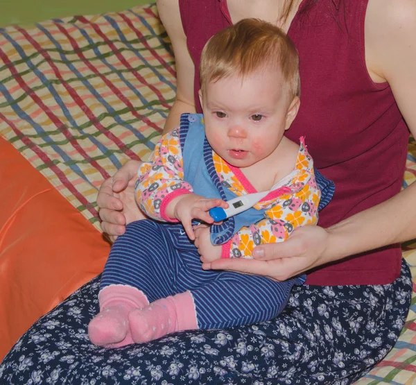 Met een thermometer onder mijn arm in de handen van haar moeder noodlijdende kind — Stockfoto