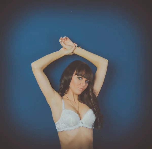 Modelo menina em lingerie branca no fundo azul — Fotografia de Stock