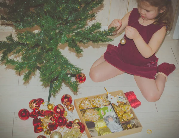 Árbol de Navidad colgando juguetes de decoración niña — Foto de Stock