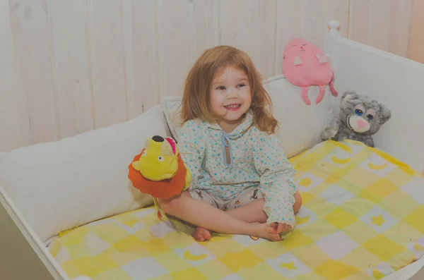 Bebek kız yatak, oyuncaklar ile yatakta oturan hazırlanıyor — Stok fotoğraf