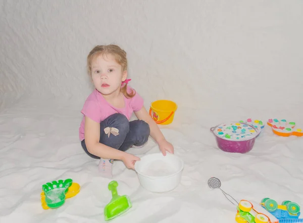 Het meisje kind in de zoutgrot behandelingen voor ademhaling en speelgoed uit verveling — Stockfoto