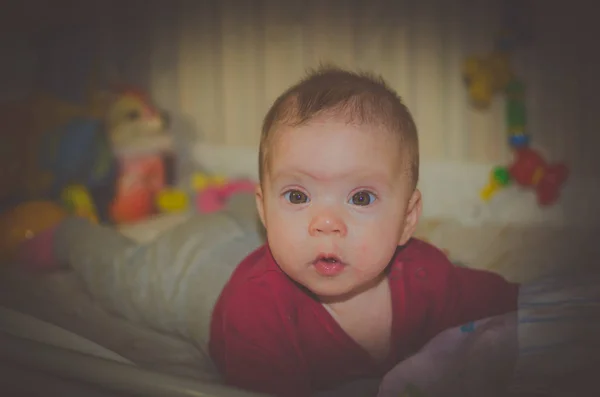 Bayi terletak di tempat tidur bayi melihat kamera sangat hati-hati — Stok Foto