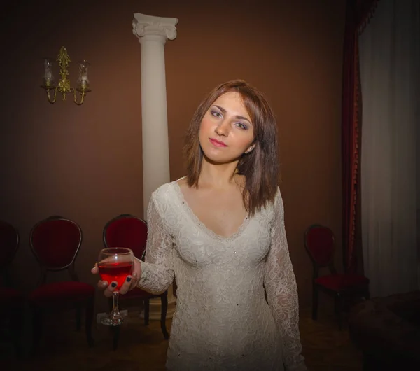 No lobby do hotel a menina com um copo de vinho — Fotografia de Stock