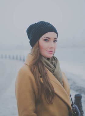 Kışın sahildeki bir güzel kız yürüyor.