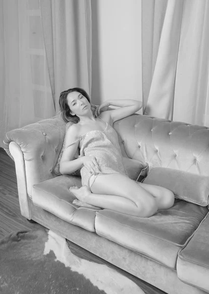 På sängen sexy girl i minimala klänning. svart och vitt. — Stockfoto