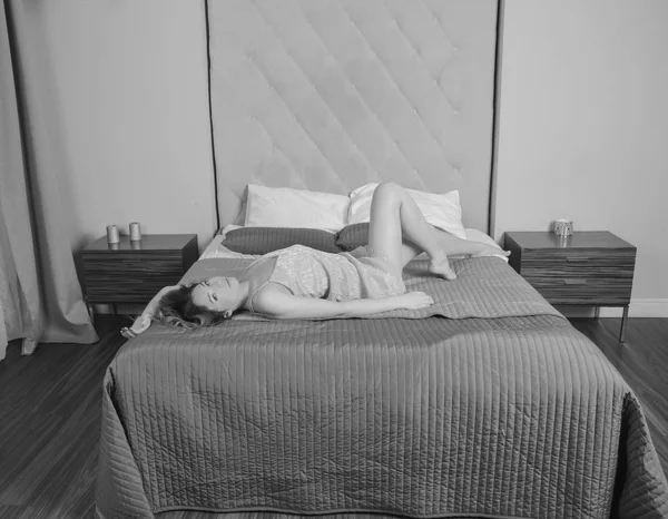 Az ágy szexi lány, a hálószobában egy leleplező ruhát. fekete-fehér — Stock Fotó