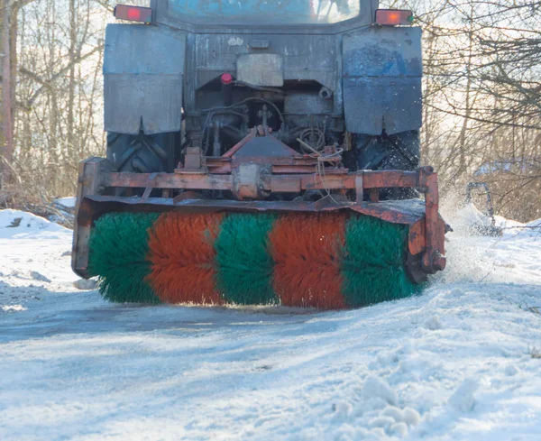 Trator remove escova a neve da estrada . — Fotografia de Stock